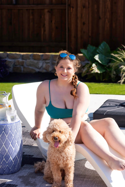 Las Olas Luxury Lounger - girl sitting poolside with doodle puppy on lounge chair.