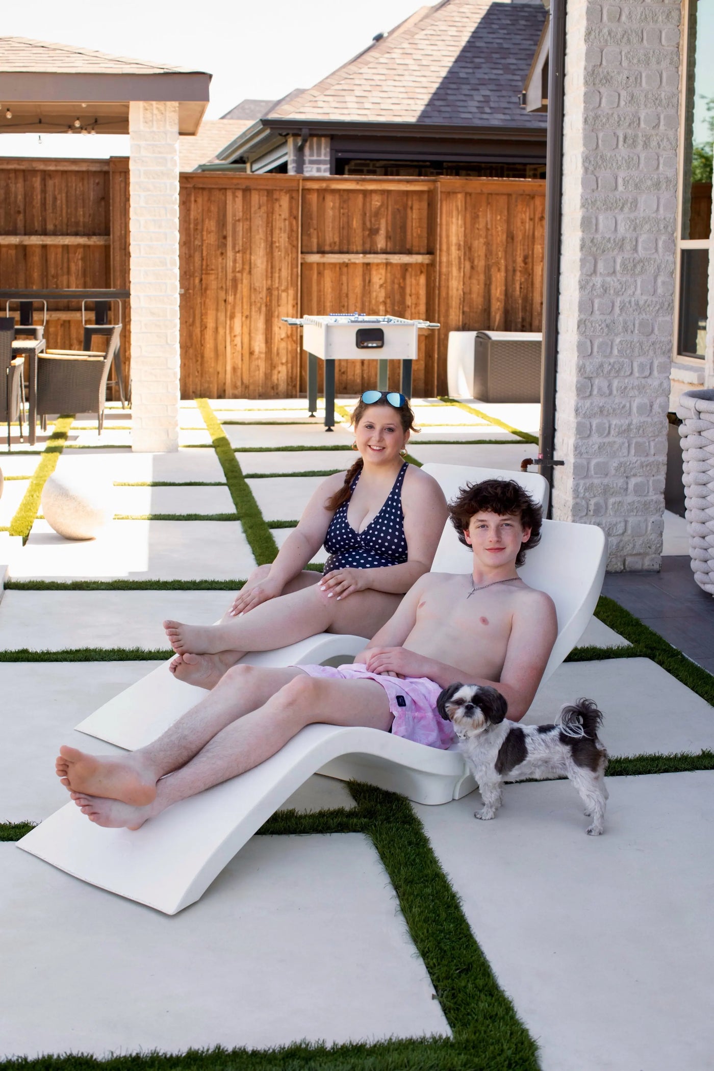 Las Olas Luxury Loungers - two teenagers lounge poolside with dog.